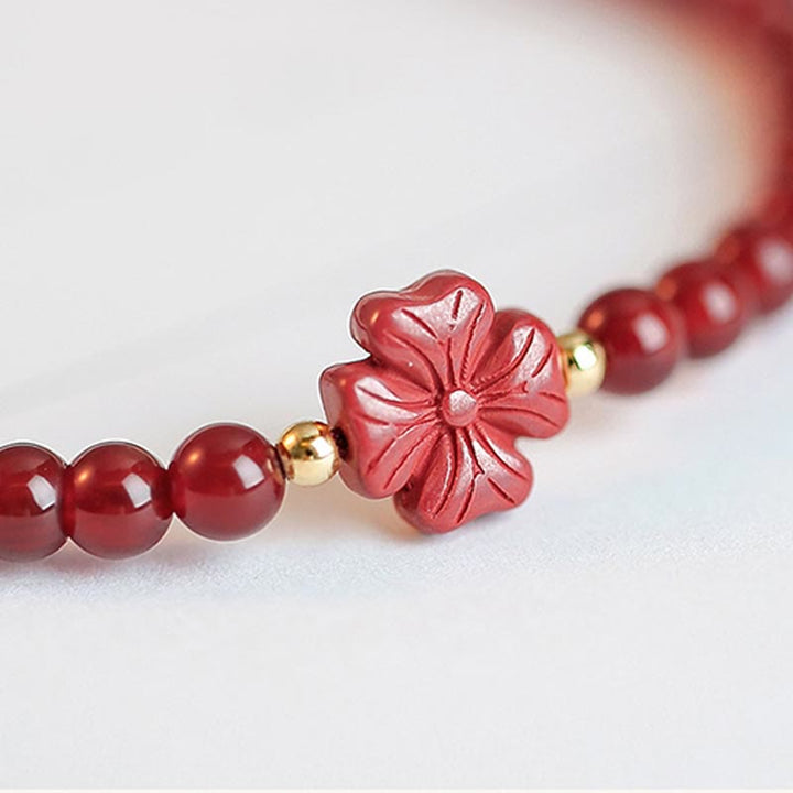Rotes Achat Armband mit Kleeblatt Charm und Goldperlen elegant.