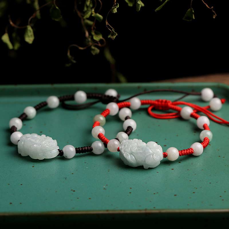 Jade Pixiu Armband mit weißen Perlen und roten Seidenfäden elegant.