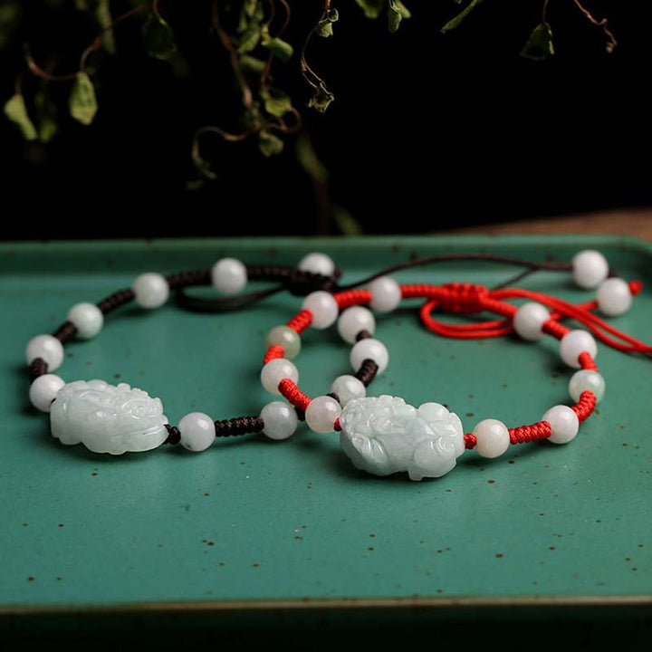Jade Pixiu Armband mit weißen Perlen und roten Seidenfäden elegant.