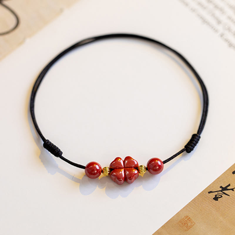 Armband Zinnober Kleeblatt rotes Perlenarmband schwarzes Elastikband Flachaufnahme