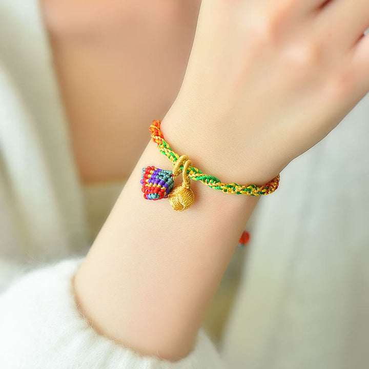 Buntes Armband mit Glückszongzi Anhänger am Handgelenk getragen.