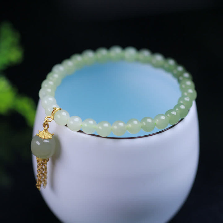 Hellgrünes Jade Armband mit goldenen Perlen und Quaste elegante Armschmuck.