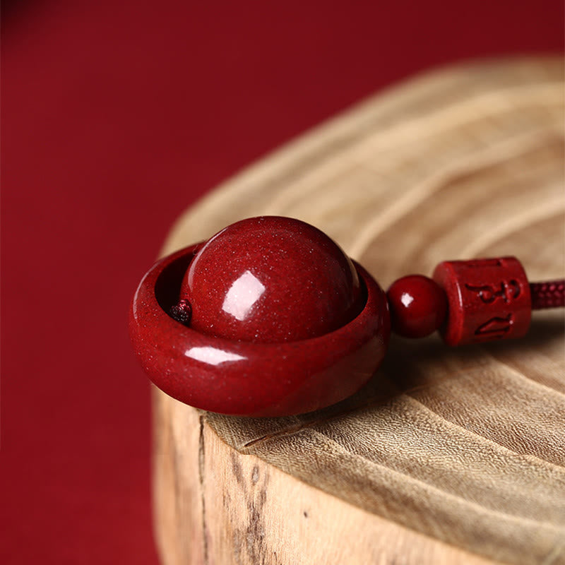 Rote Zinnober PiXiu Kette mit Edelstein auf Holzoberfläche.