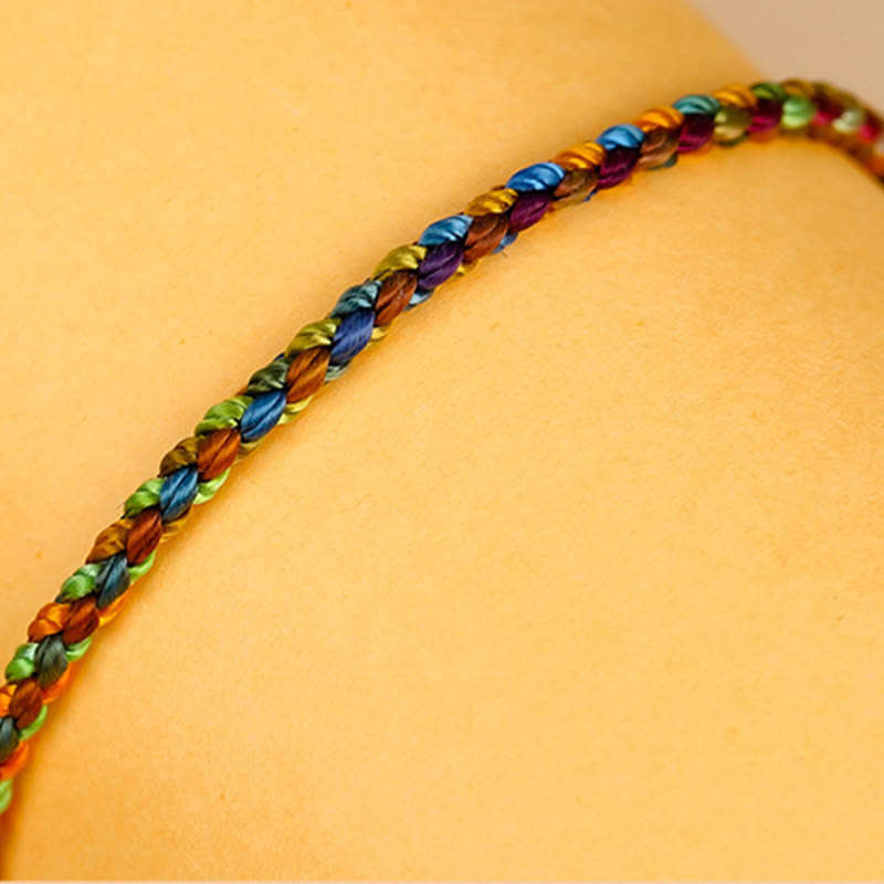 Regenbogen Armband „Glück" mit bunten Perlen auf gelbem Hintergrund