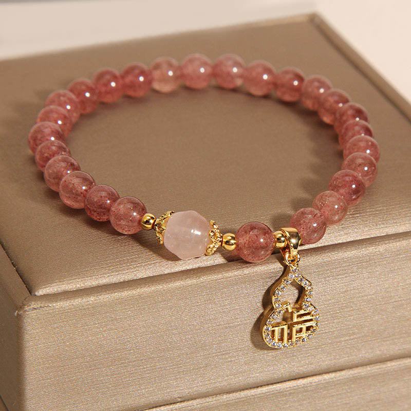 Armband Erdbeerquarz Fu-Zeichen rosa Perlen goldene Verzierungen elegant.