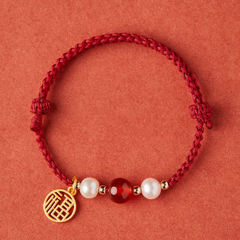 Rotes Armband mit Perlen, Achat und goldenem Fu-Zeichen Anhänger.