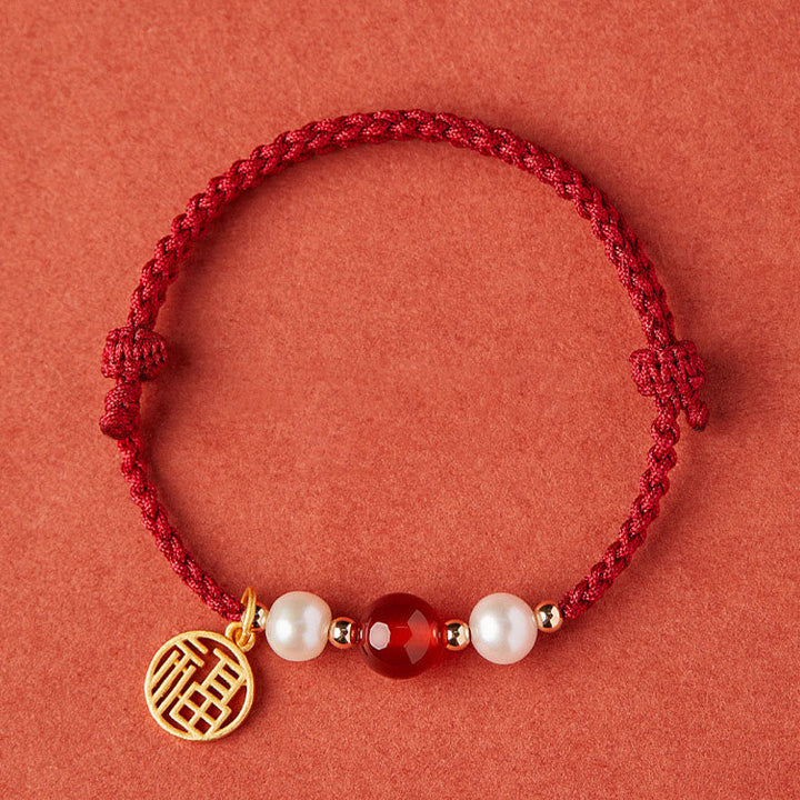 Rotes Armband mit Perlen, Achat und goldenem Fu-Zeichen Anhänger.