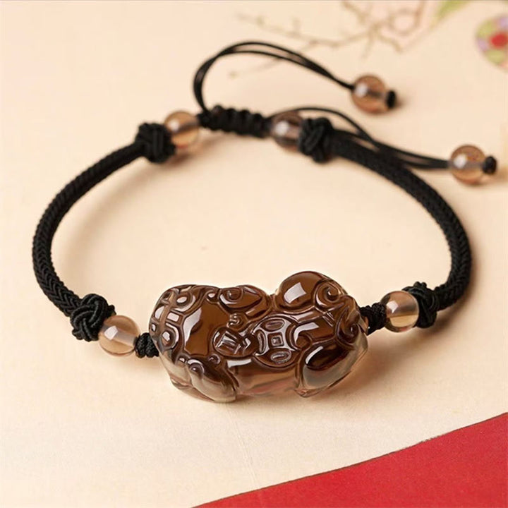 Braunes Pixiu Armband mit schwarzem Seil und Perlen elegantes Design.