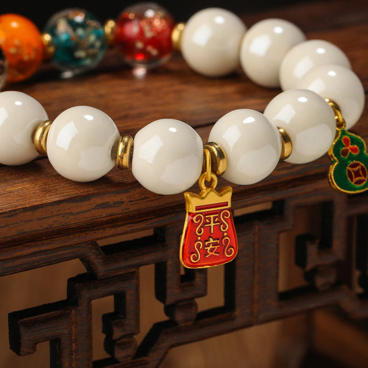 Weißes Jadeit Armband mit goldenen Accessoires und Anhänger elegant.