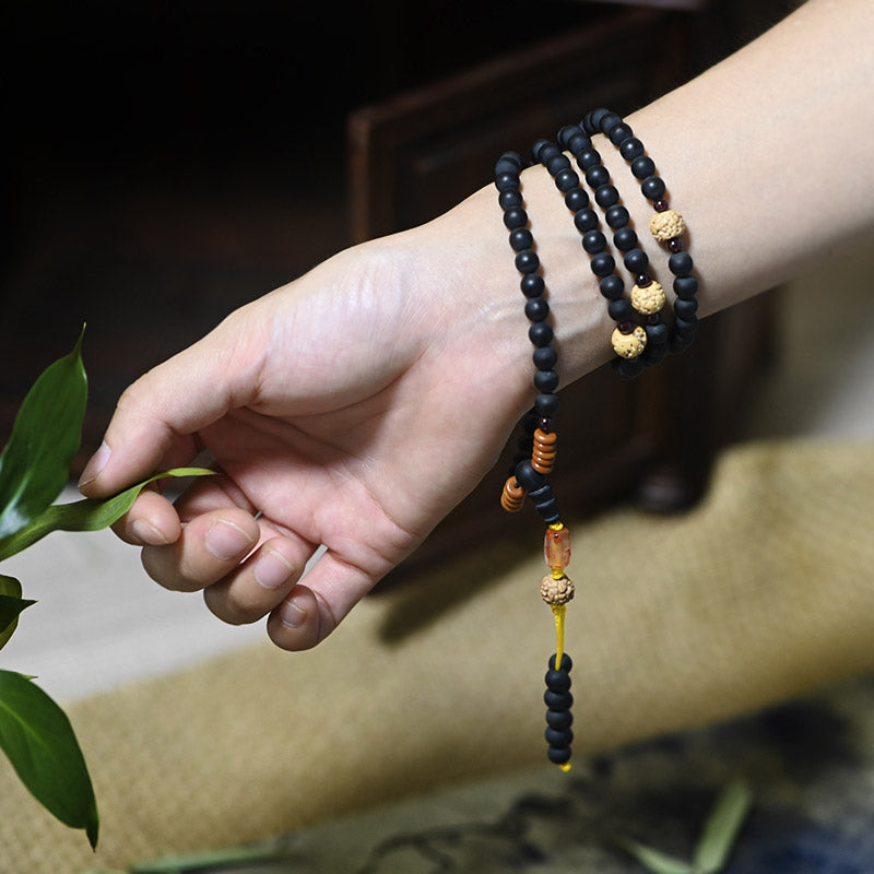 Mala Armband am Handgelenk, schwarze Perlen mit goldenen Spacern, Heilstein Schmuck