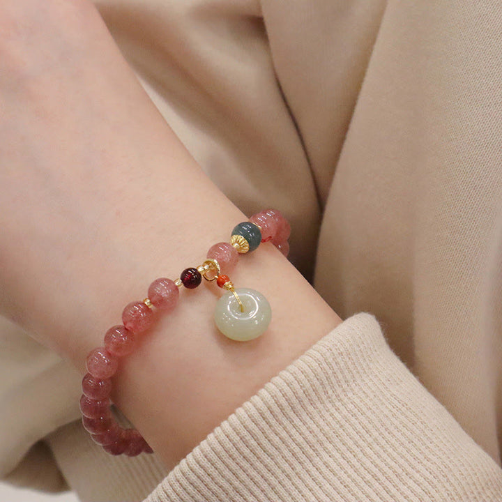 Armband Erdbeerquarz Jade am Handgelenk mit Anhänger elegant getragen