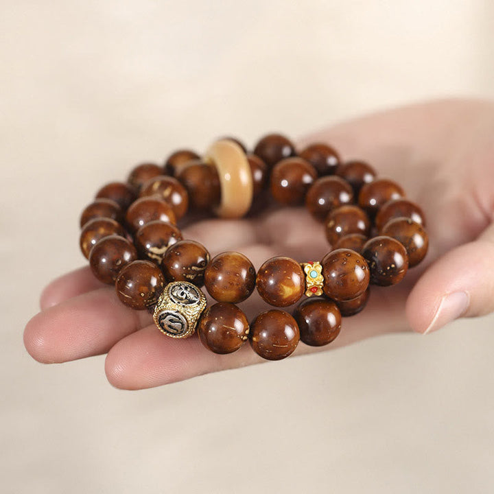 Bodhi Armband mit braunen Perlen und Metallakzenten am Handgelenk getragen