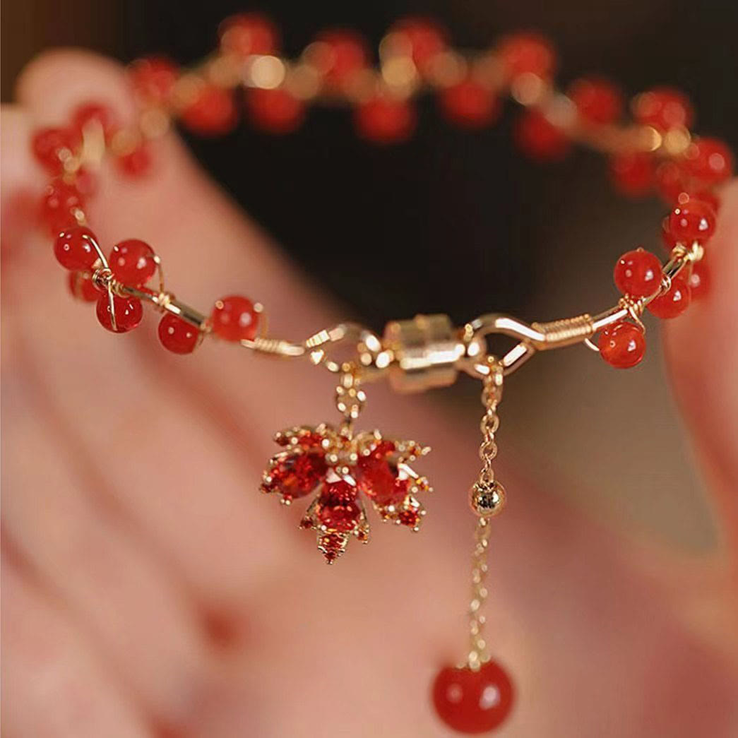 Rotes Ahornblatt Armband mit goldenen Perlen elegant getragen