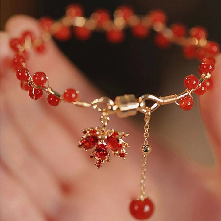 Rotes Ahornblatt Armband mit goldenen Perlen elegant getragen
