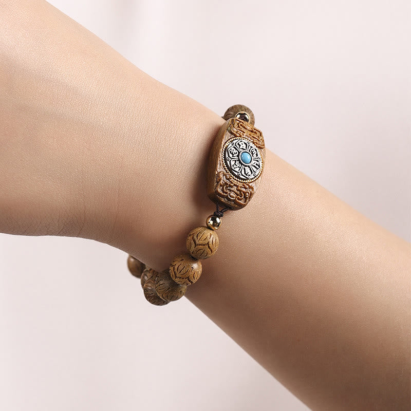 Sandelholz Armband mit Om Symbol am Handgelenk elegant getragen