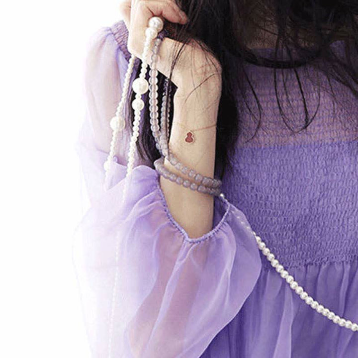 Amethyst Kristall Armband elegant am Handgelenk mit Perlen getragen.