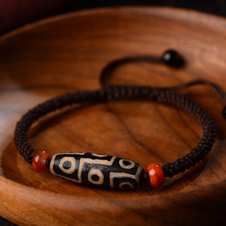 Armband Dzi-Perle Neun Augen auf Holz, schwarze Kordel, rote Perlen, Wohlstand.