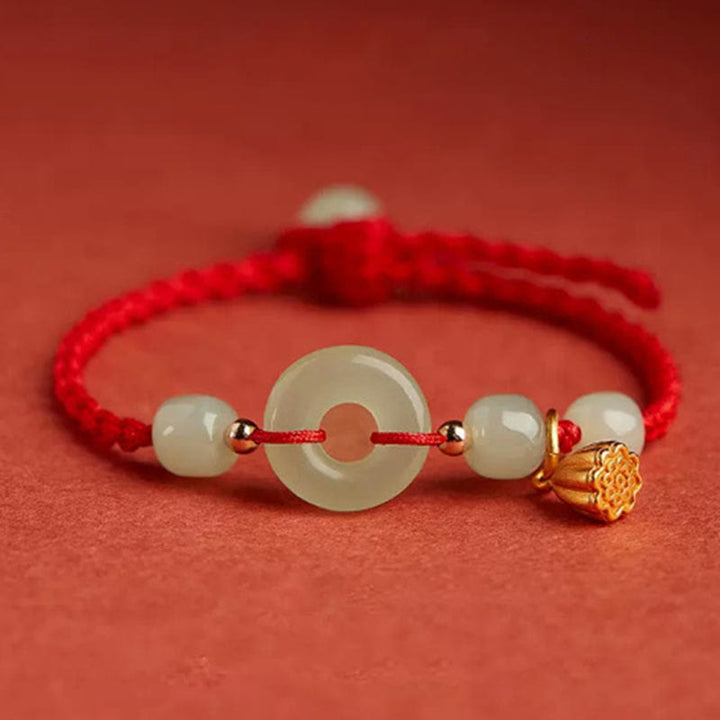 Armband Jade Lotus – Wohlstand & Frieden mit hellgrüner Jade auf rotem Hintergrund