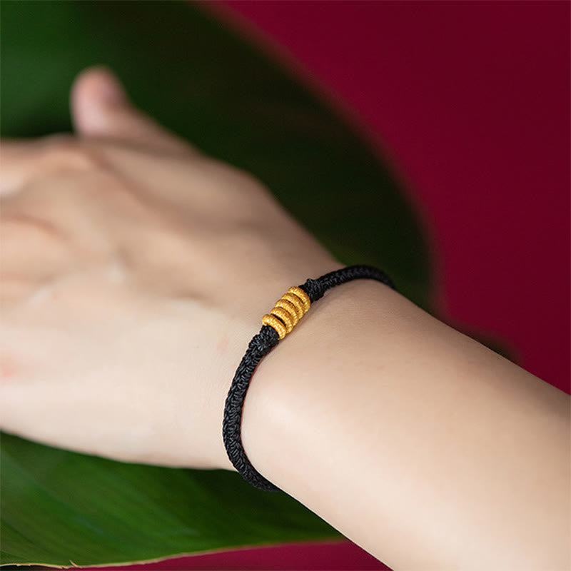 Schwarzes Armband mit goldenen Perlen am Handgelenk getragen Schutz Glück Energie
