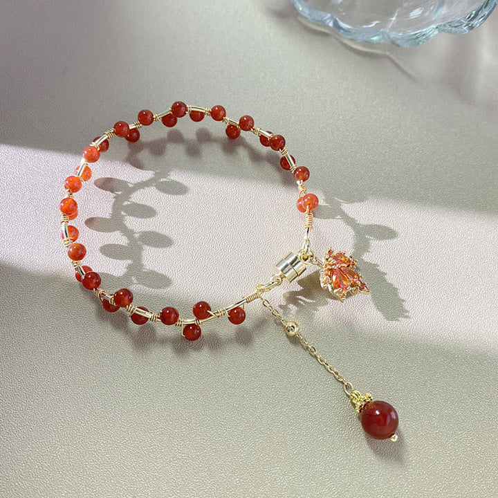 Rotes Armband mit Ahornblatt Charm und Glücksbringer Anhänger.