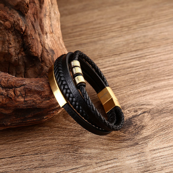 Schwarzes magnetisches Armband mit Goldverschluss auf Holz.