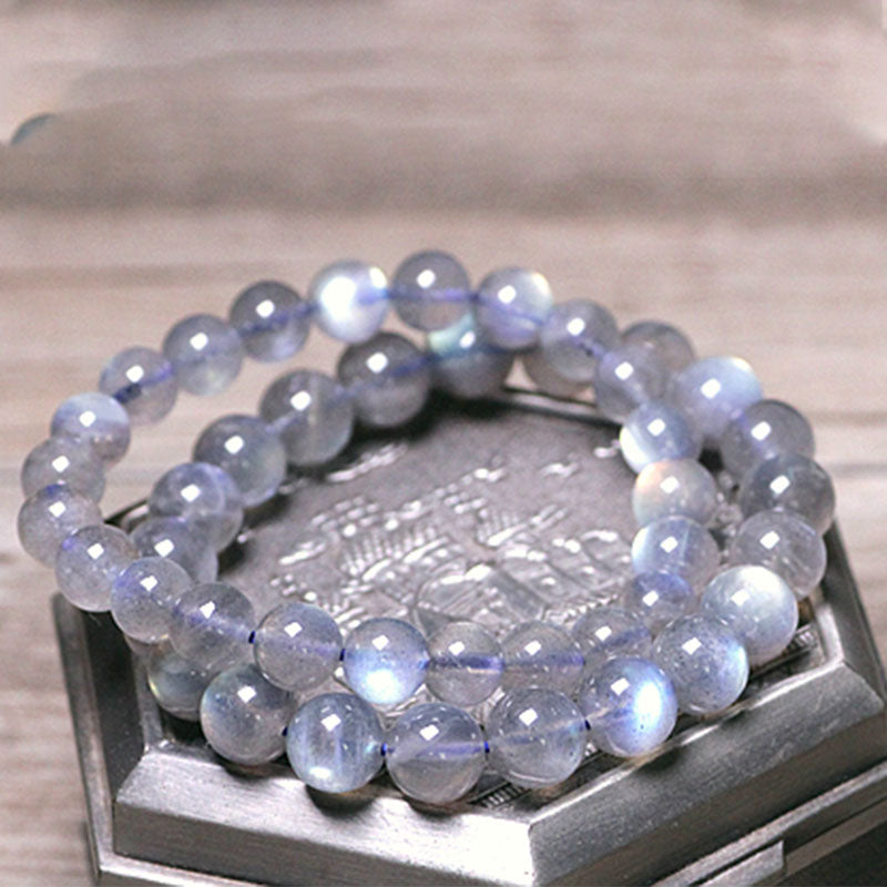 Armband Mondstein Mond – Ruhe mit facettierten Perlen auf Holz.