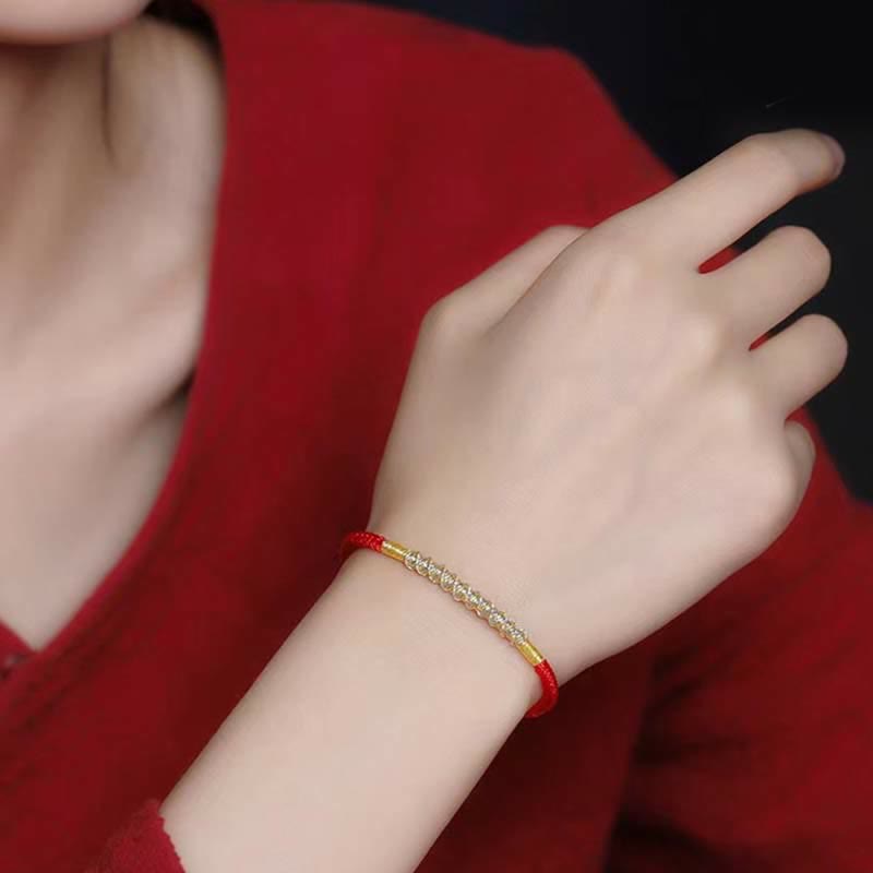 Rotes Armband mit goldenen Perlen am Handgelenk getragen elegant