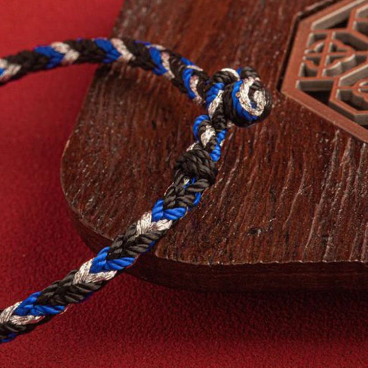 Armband Mehrfarbig Glücksband blau schwarz weiß geflochten Holz Untergrund