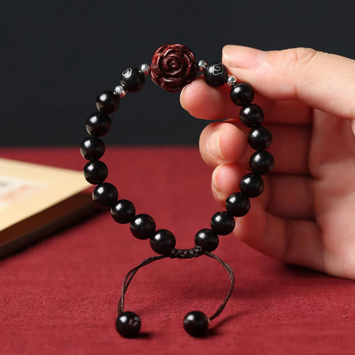 Armband Sandelholz mit schwarzen Perlen und roter Rose Blüte.