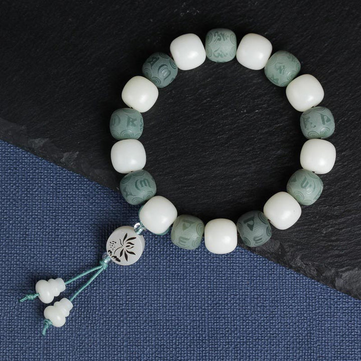 Armband Weiße Jade Bodhi Om Mani auf dunklem Untergrund, Schmuckfoto