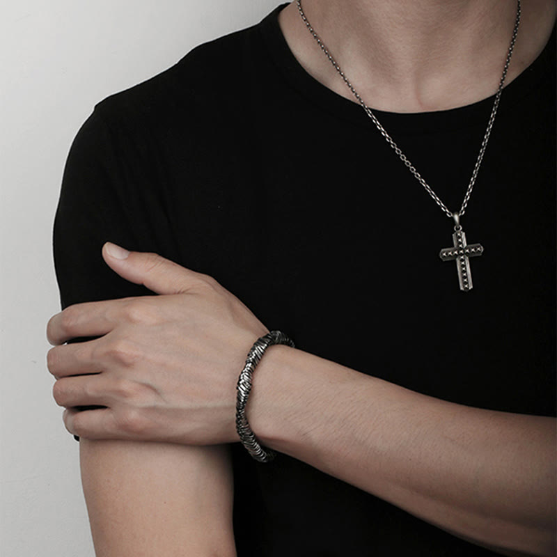 Silberarmband mit Kreuzanhänger an männlichem Handgelenk getragen elegant