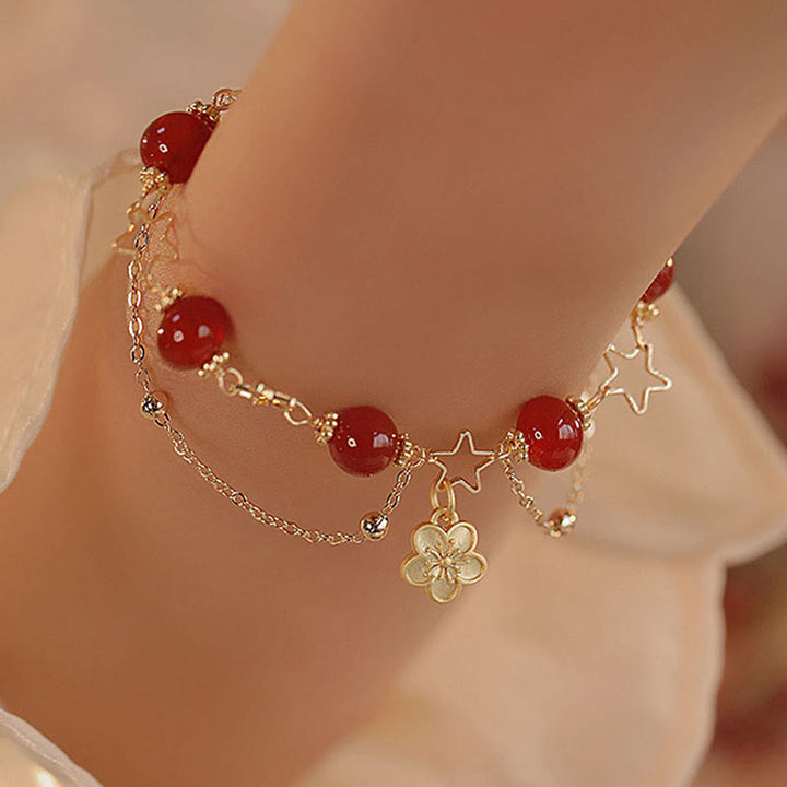 Armband Roter Achat Stern – Ruhe am Handgelenk mit goldenen Kettendetails getragen
