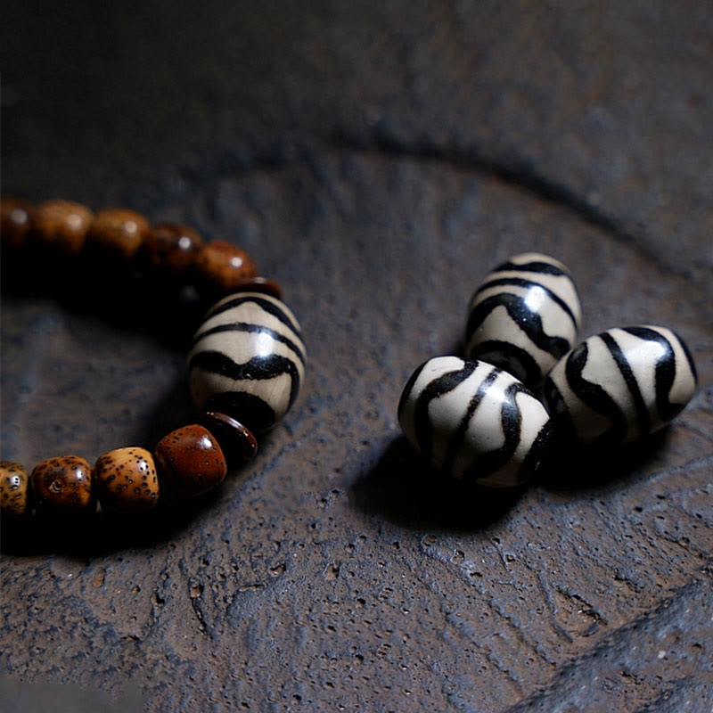 Bodhi Achat Armband mit braunen und weißen Perlen auf Stein.
