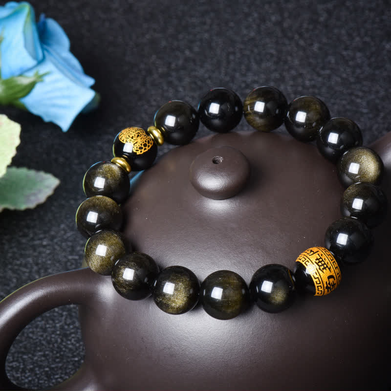 Obsidian Armband mit goldenen Perlen auf Teekanne elegant präsentiert.