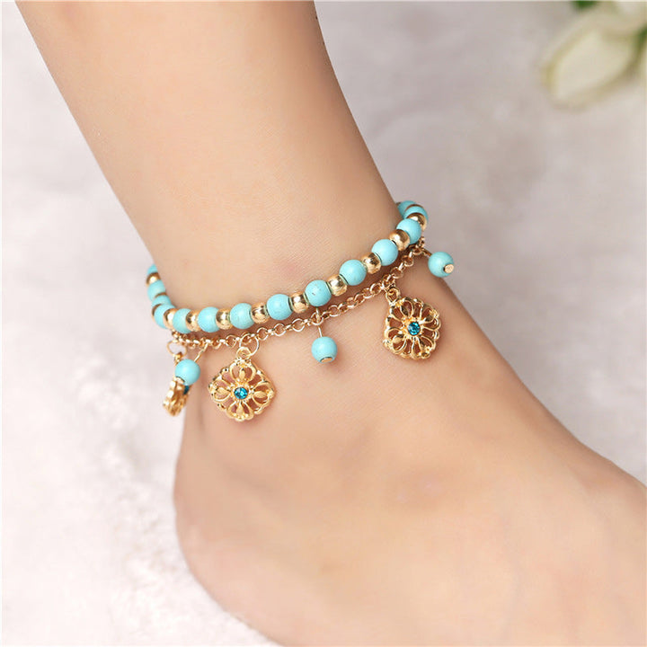 Armband Türkis – Schutz mit goldenen Anhängern elegant am Handgelenk getragen