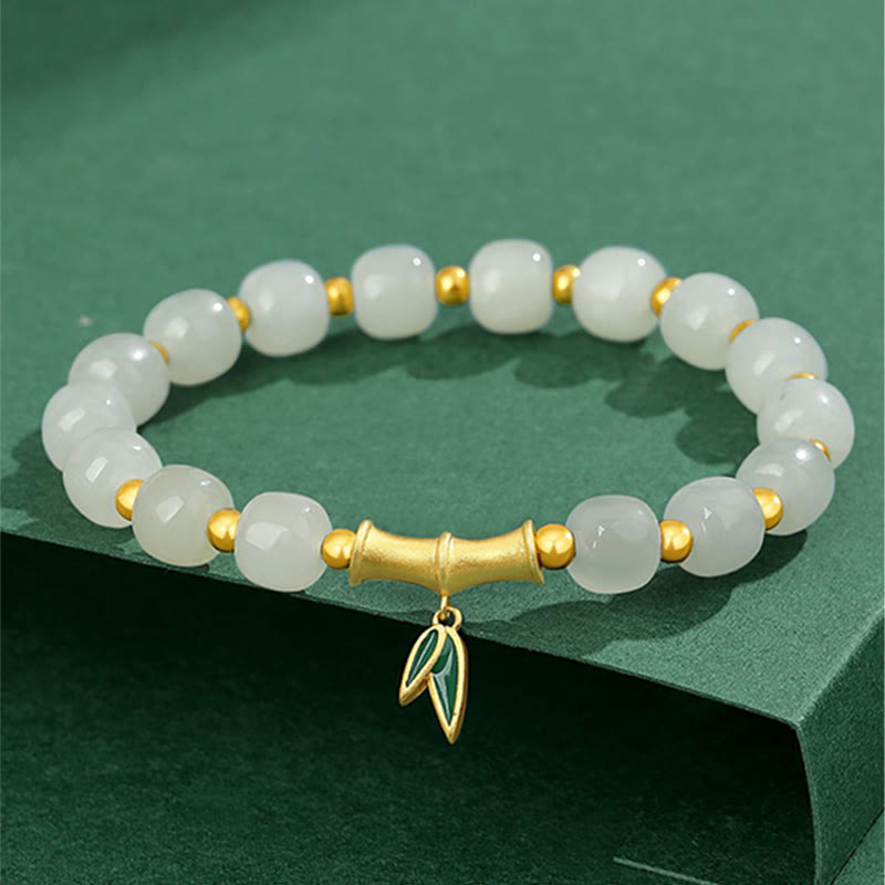 Weißes Jade Armband mit goldenen Perlen und Blattanhänger elegant.