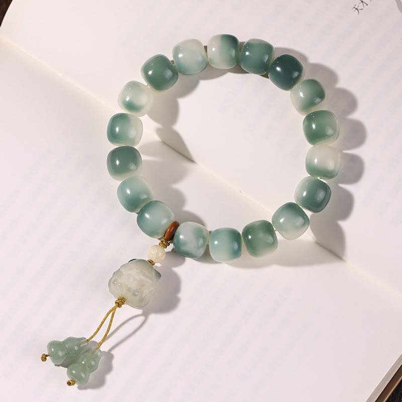 Grünes Jade Armband mit Bodhi-Anhänger auf weißem Hintergrund displayiert.