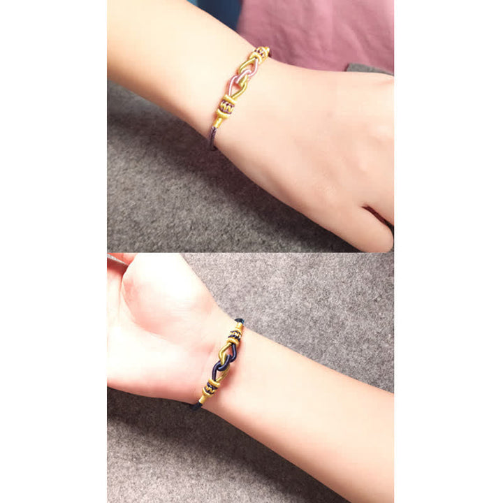 Geflochtes Armband Knotting Faith Stärke goldfarben am Handgelenk getragen.