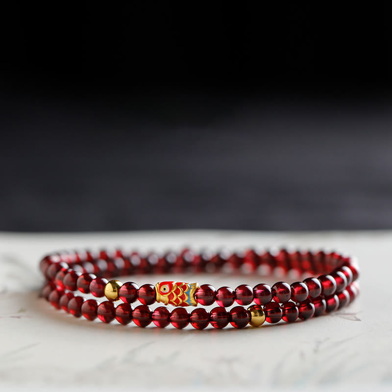 Armband Granat Koi Fisch – Schutz rote Perlen elastisch Marmor Hintergrund