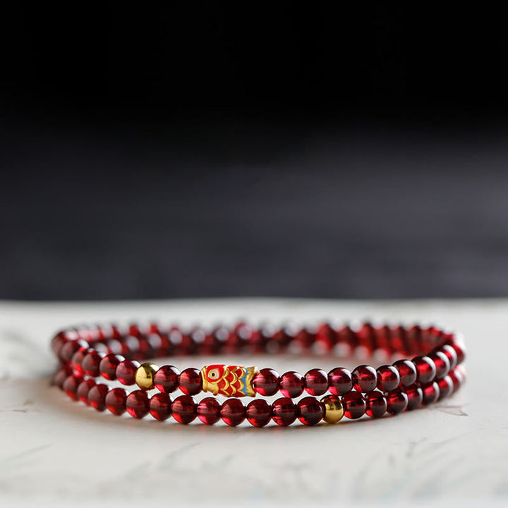 Armband Granat Koi Fisch – Schutz rote Perlen elastisch Marmor Hintergrund