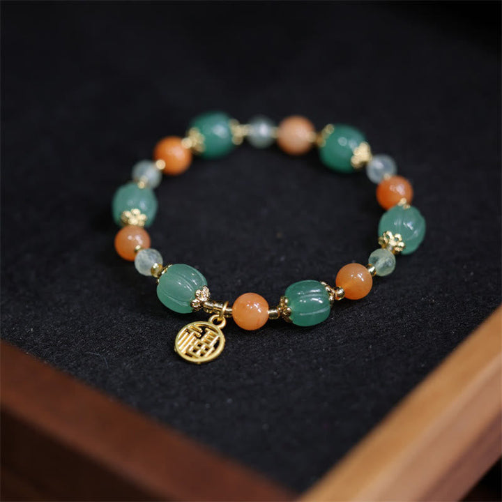 Jade Armband mit grünen Steinen, orangefarbenen Perlen und Fu-Zeichen Anhänger.