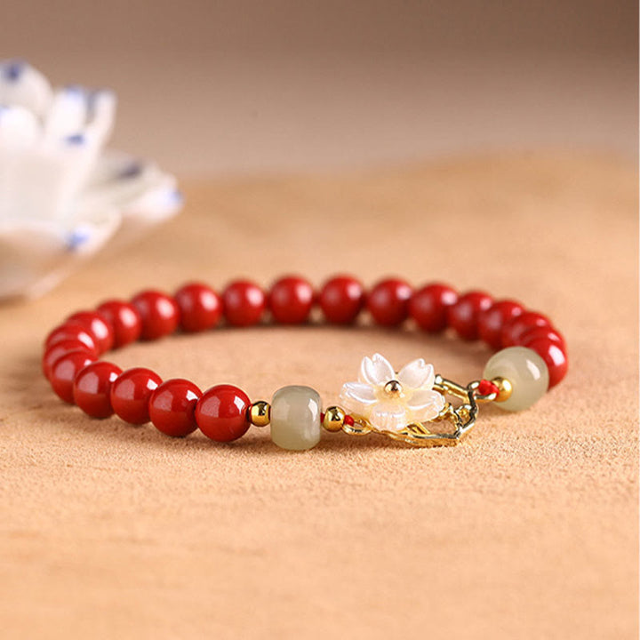Armband Zinnober Jade – Segen mit roten Perlen und Blütenschmuck