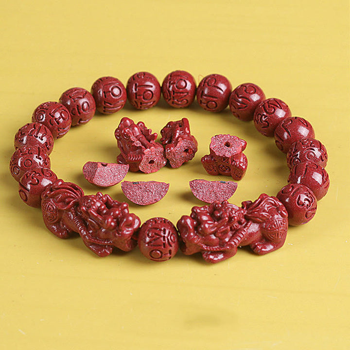 Zinnober Om Mani Padme Hum Armband mit roten Perlen und Glücksbringern.