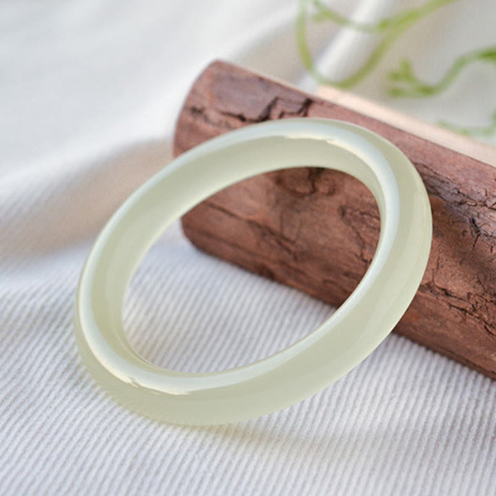 Jade Armband Fülle cremeweiß Naturstein elastisch Holz Hintergrund