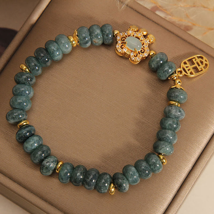 Jade Armband mit goldenen Elementen und Glücksanhängern getragen
