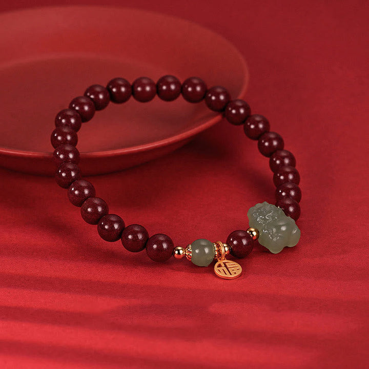 Rotes Armband mit Granaten und Jade-Anhänger elastisch getragen