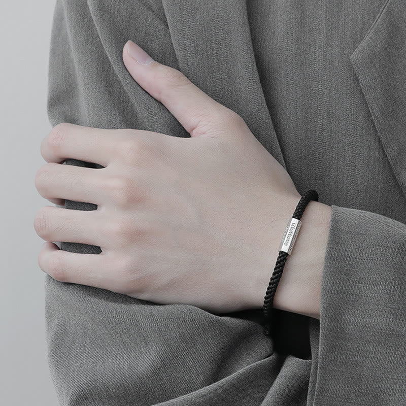 Schwarzes Armband mit Metallplakette am Handgelenk getragen elegant