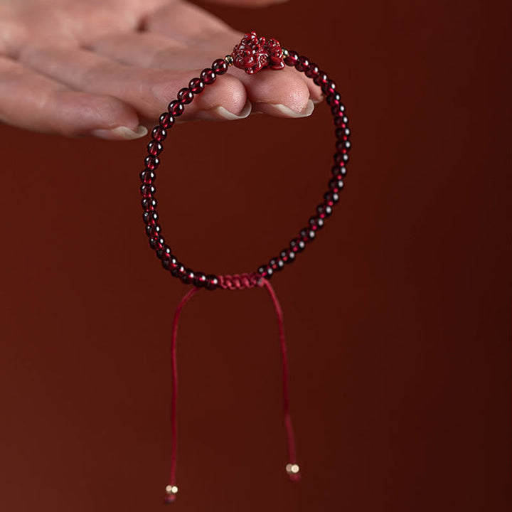 Armband Zinnober Granat Pixiu elastisch mit roten Perlen getragen