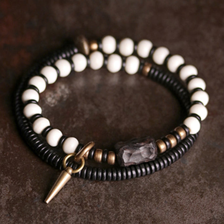 Armband Kupfer Ebenholz Paar Stärke weiße Perlen schwarze Ringe Nahaufnahme