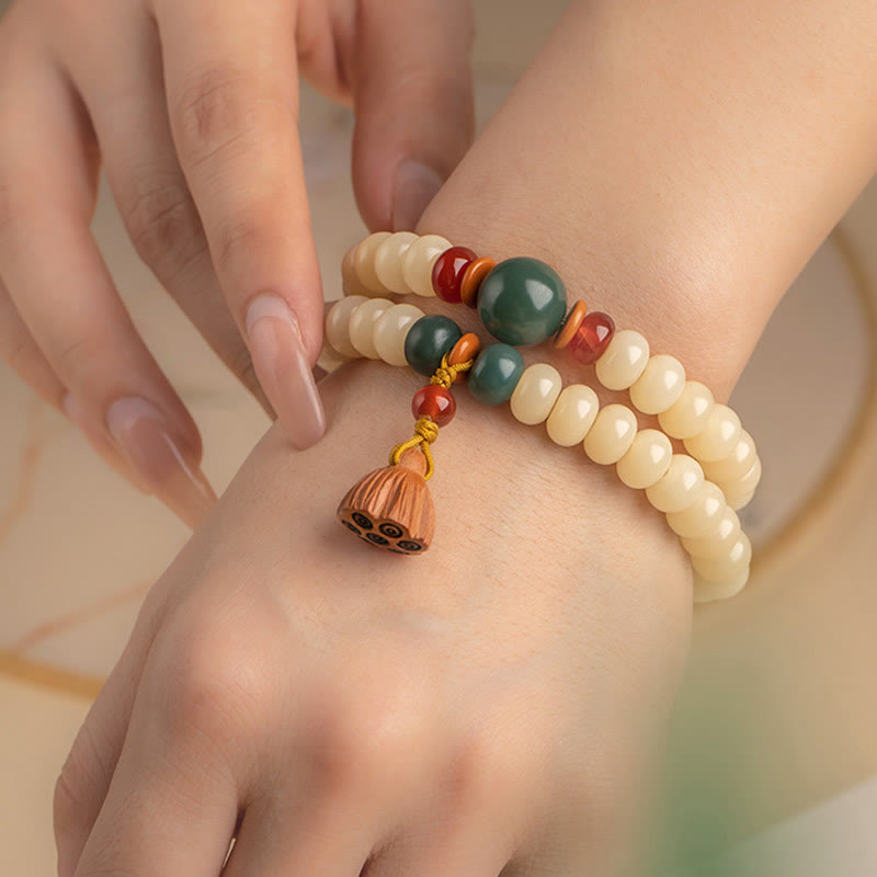Bodhi Lotus Armband mit cremefarbenen Perlen und grünem Stein am Handgelenk